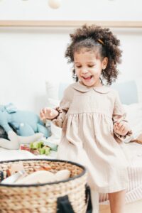 Mädchen sortiert Spielzeug im Kinderzimmer