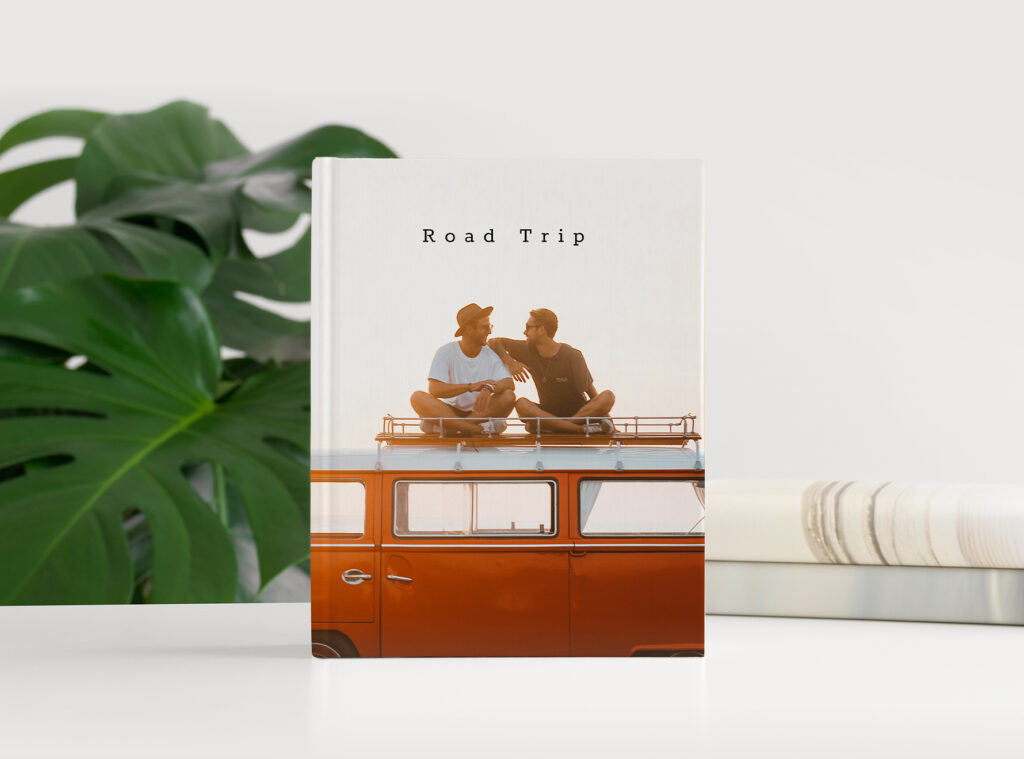 Urlaubsfotobuch: Ein Fotobuch mit Roadtrip-Cover steht auf dem Tisch.