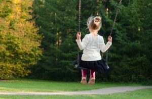 Authentische Kinderfotografie: Mädchen beim Schaukeln